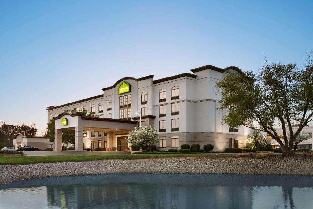 a hotel building with a pond in front of it at Wingate by Wyndham Cincinnati Blue Ash in Blue Ash