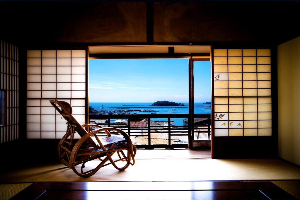 a room with an open door with a view of the ocean at そわか楼 in Fukuyama