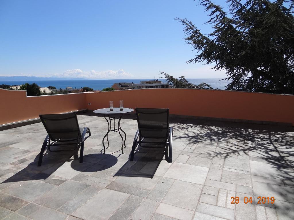 a table and chairs on a patio with a view of the ocean at Bed&BluUp in Savona