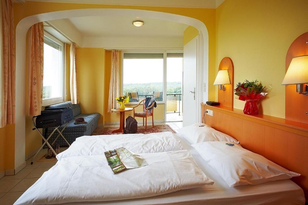een hotelkamer met een bed en een groot raam bij Hotel Perekop in Berdorf