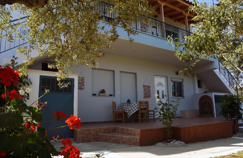 a house with a blue door and a balcony at Mina Apartments in Zacharo