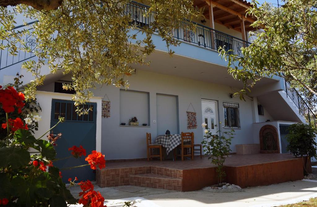 ein Haus mit einer blauen Tür und einem Balkon in der Unterkunft Mina Apartments in Zakharo