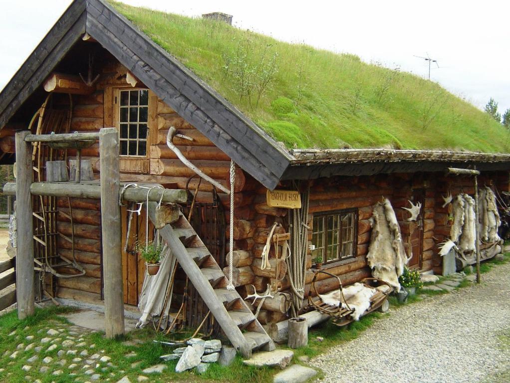 uma cabana de madeira com telhado de relva em Engholm Husky Design Lodge em Karasjok
