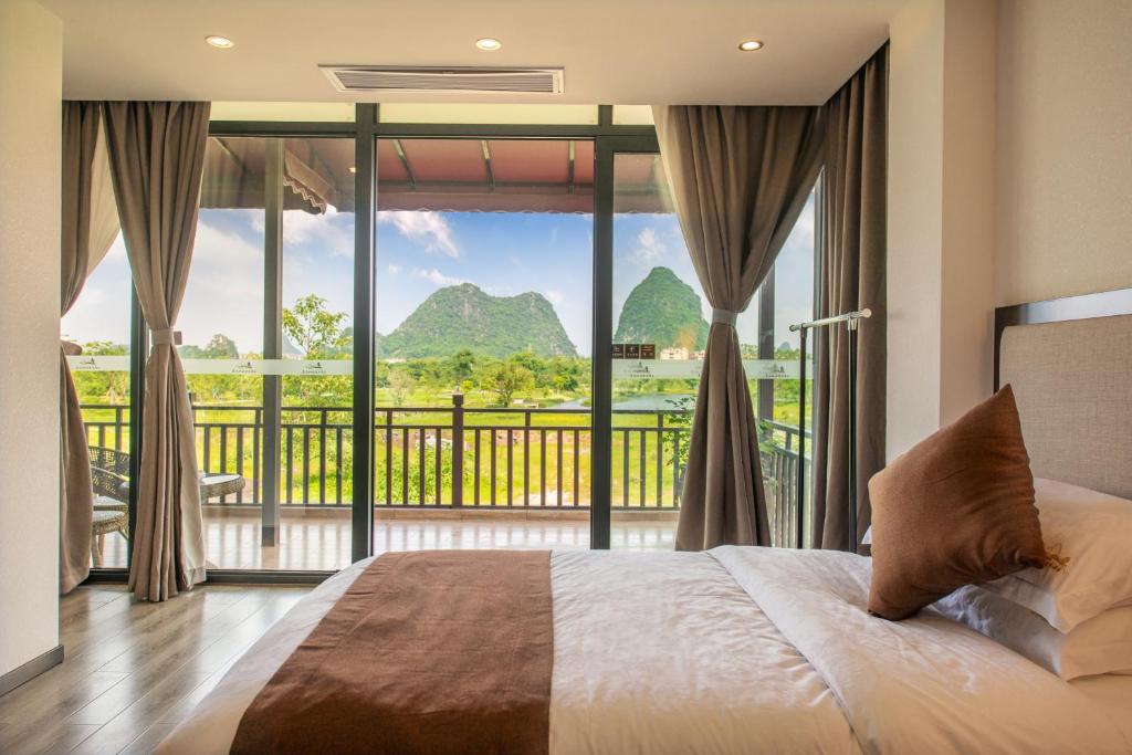 una camera da letto con un letto e una grande finestra di Peach Blossom Resort Hotel a Guilin