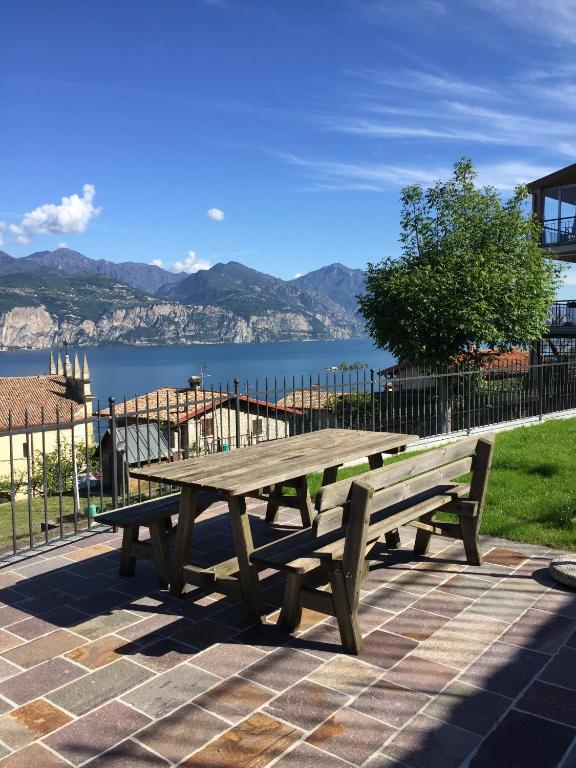 a wooden picnic table sitting on top of a brick ground at Casa Mary in Brenzone sul Garda