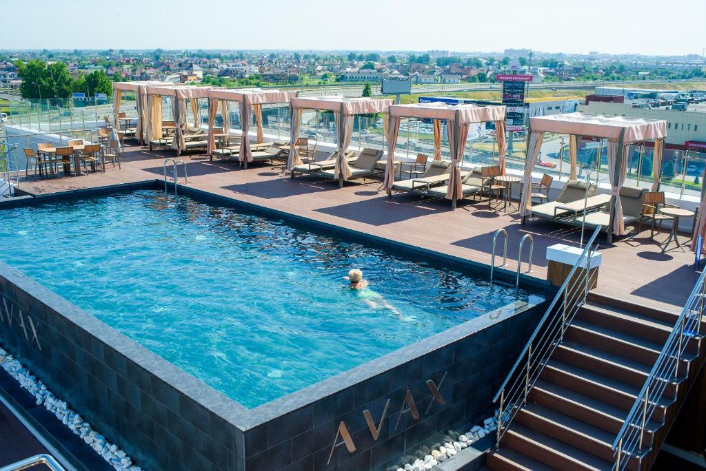 a person swimming in a swimming pool at a resort at Grand Spa Hotel Avax in Krasnodar