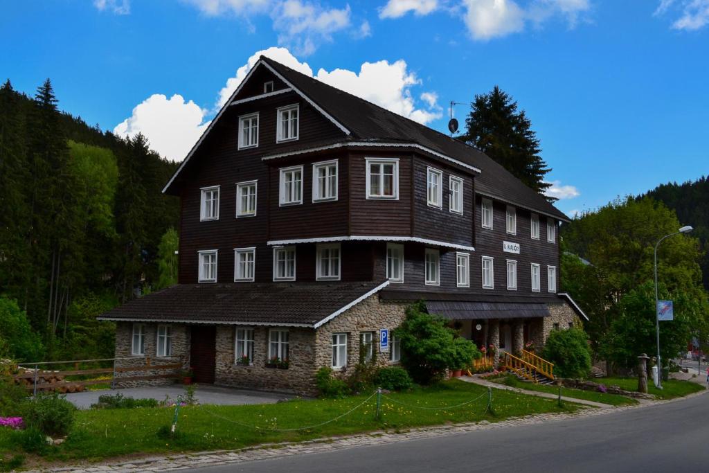 a large wooden house on the side of a road at U Kapličky in Pec pod Sněžkou