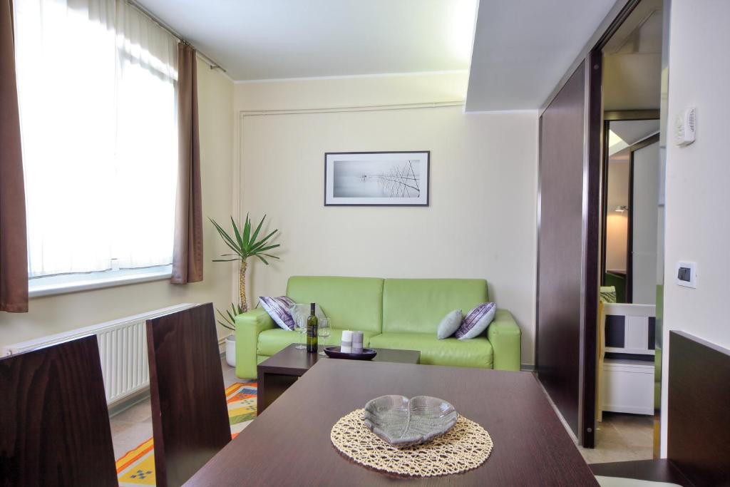 sala de estar con mesa y sofá verde en Apartma Anka ***, en Kranjska Gora