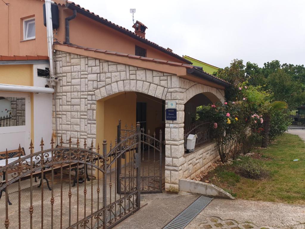 a building with a gate in front of it at Ferienwohnung Irina in Ližnjan