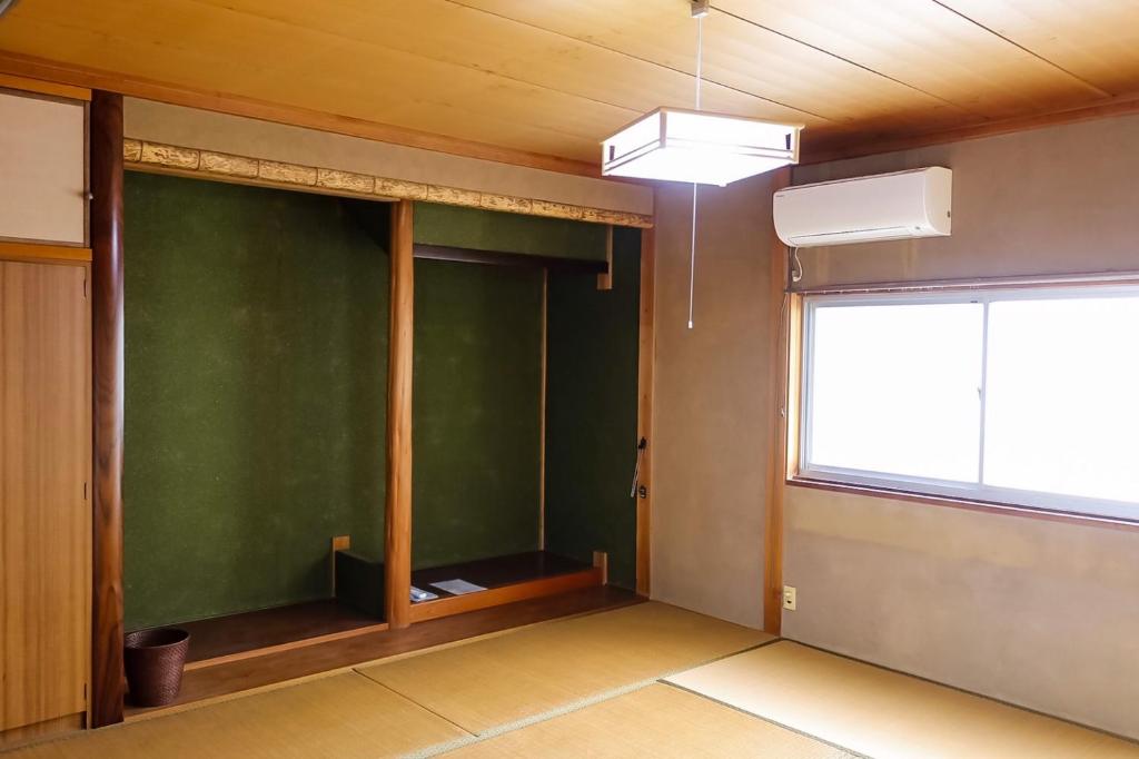 una stanza vuota con una parete verde e una finestra di 北房まちの駅 AZAE ドリトミー azae a Maniwa