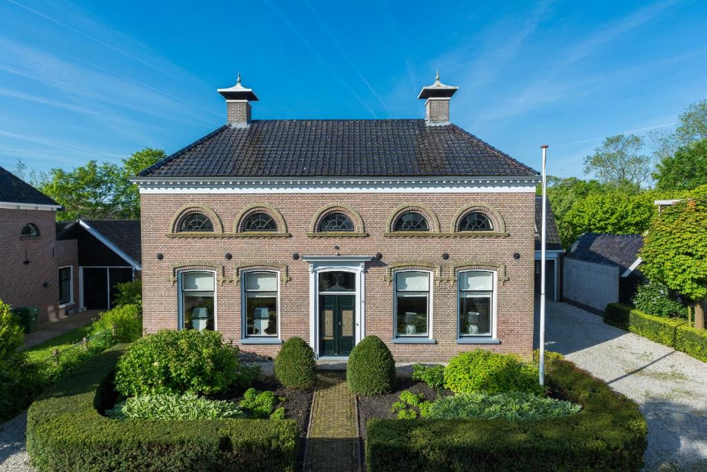 una casa de ladrillo con techo de gambrel en Elfstedenstate Friesland, en Easterein