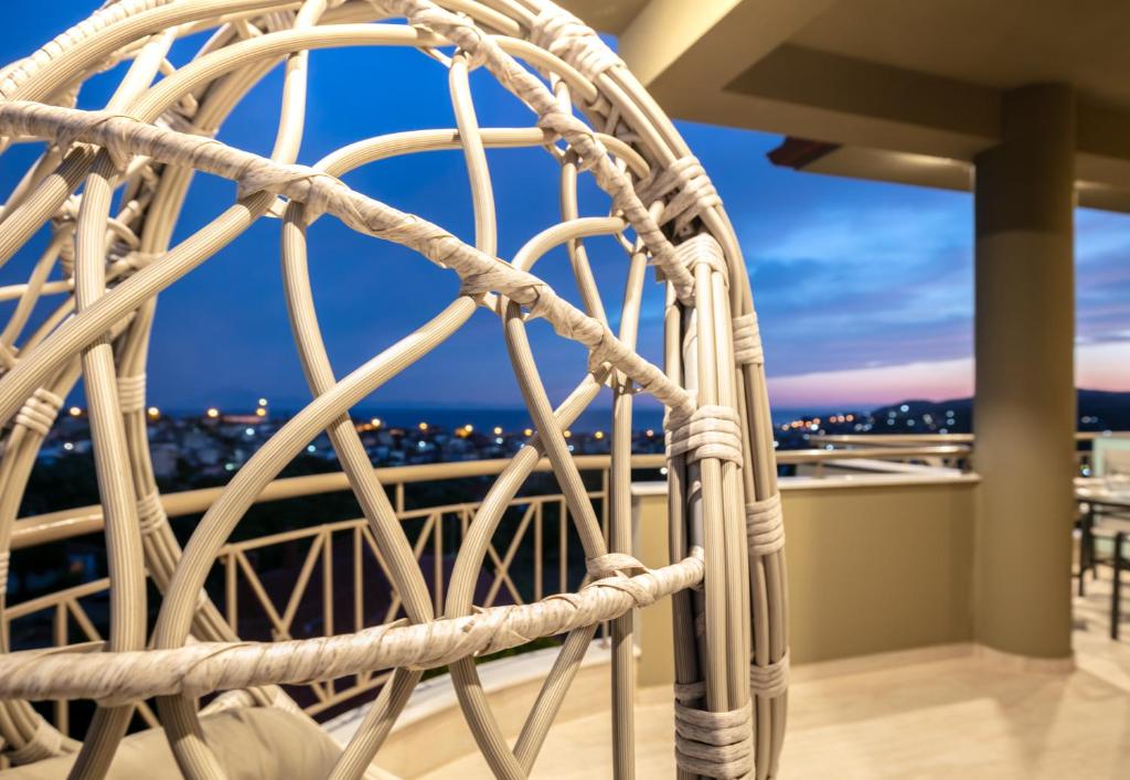 a rattan wheel on a balcony with a view of the city at DIKAP Luxury Aparts in Limenaria