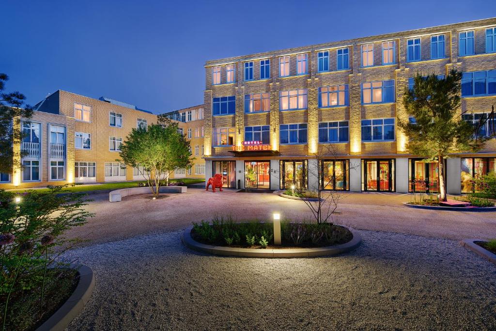 un gran edificio con un patio delante de él en Hotel the Match en Eindhoven