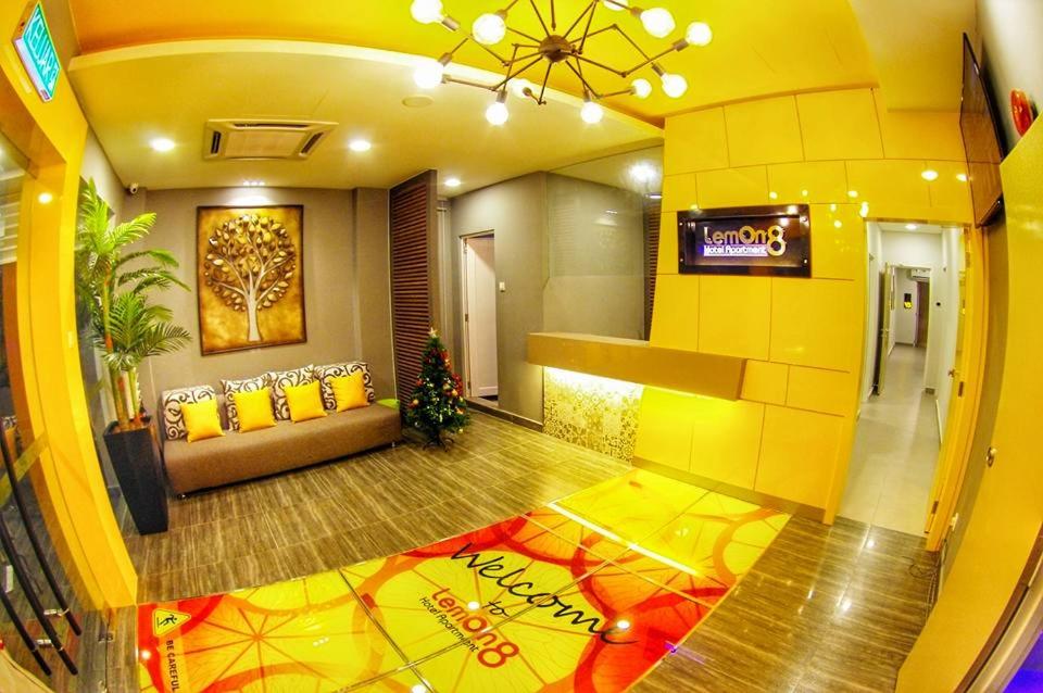 a lobby with a couch and a tv in a building at Lemon 8 Boutique Hotel @ Melaka in Melaka