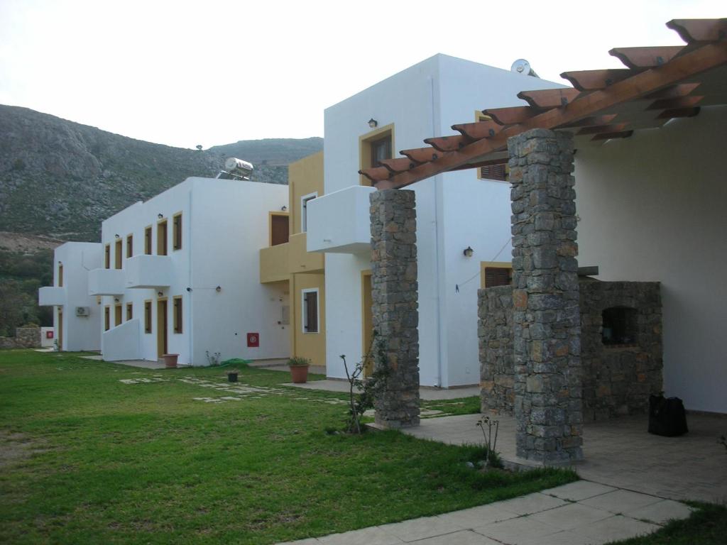 a group of white buildings with a grass yard at Tilos Fantasy in Livadia