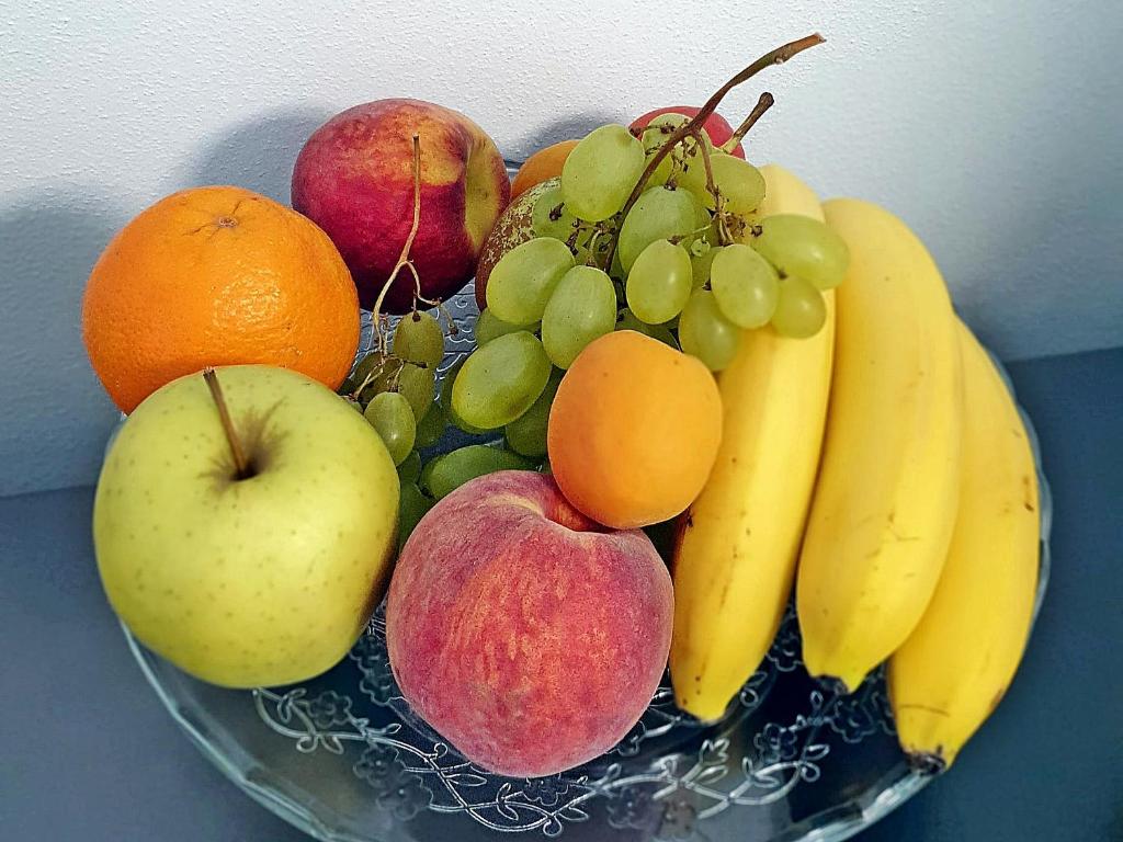 a plate of fruit with apples bananas oranges and other fruits at B&B I LAKE IT BELLAGIO in Bellagio