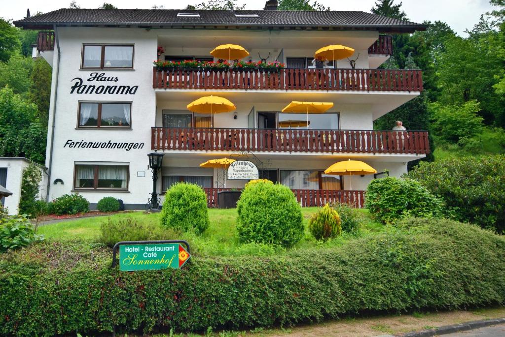 a white building with yellow umbrellas on the balcony at Haus Panorama in Simmerath