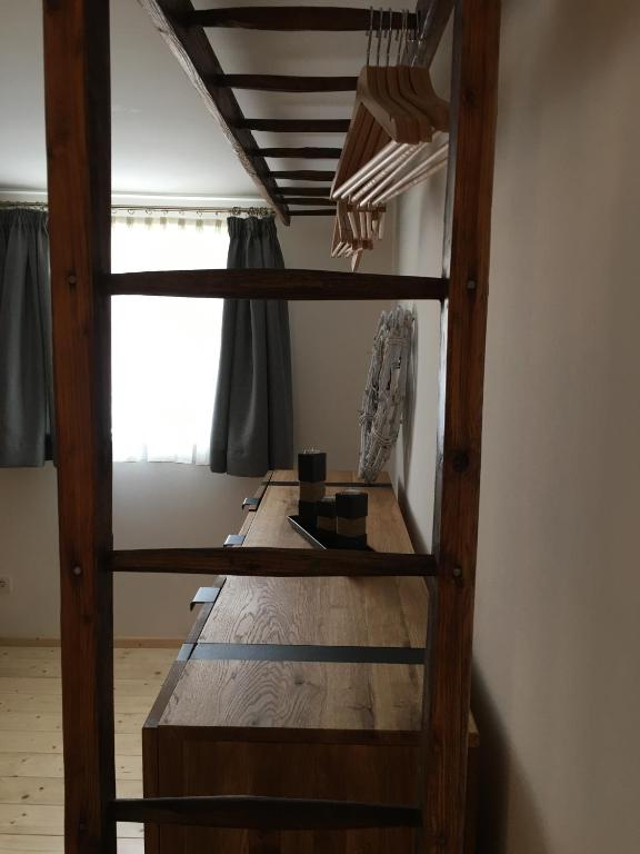 a loft bed with a wooden table in a room at Serviced Apartement Sonnleitner in Furth