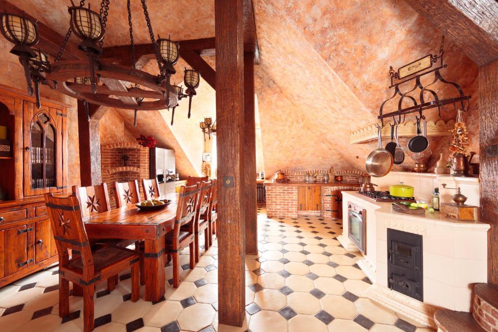 a large kitchen with a wooden table and chairs at Attic Apartment Warszawa in Warsaw