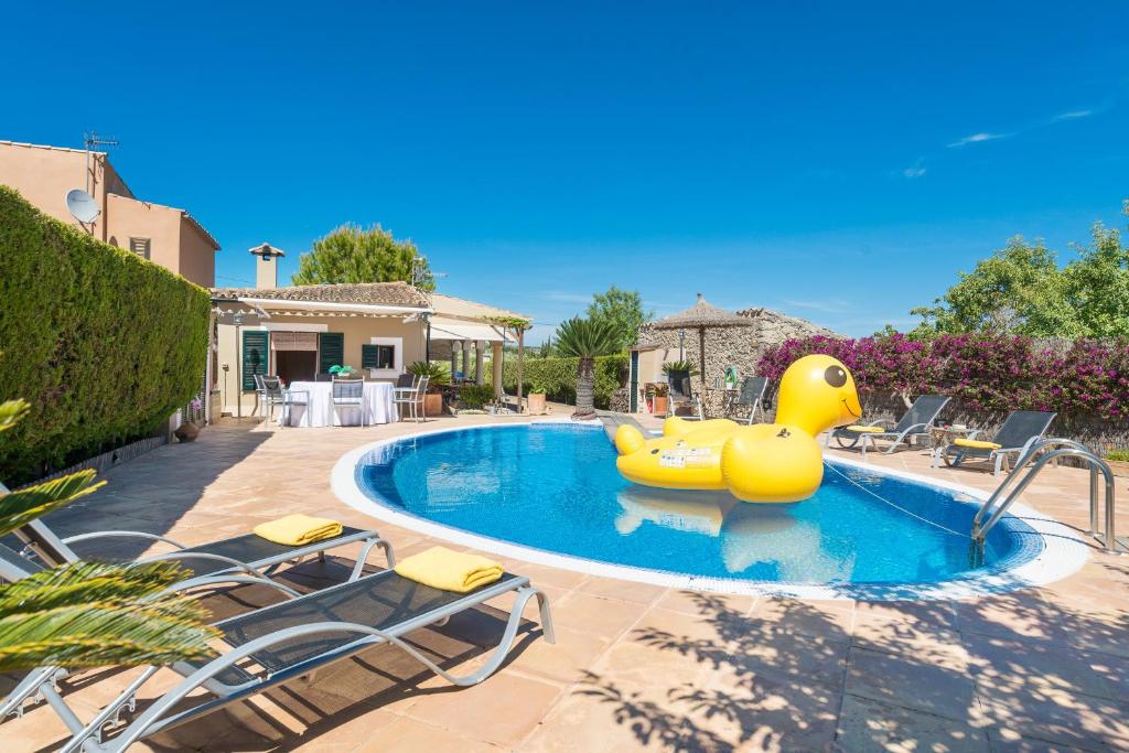 uma piscina com um pato de borracha no meio em Finca Son Macia, amplia piscina, jardines en Selva, cerca de playas em Selva