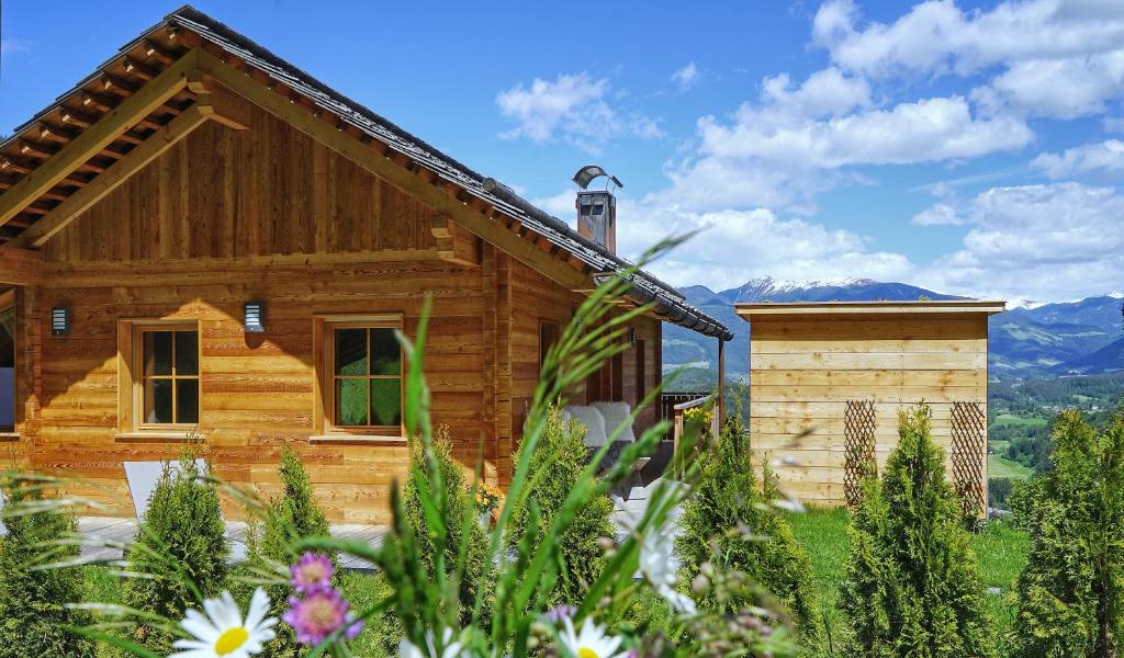 a log cabin with mountains in the background at Chalet Oberguggenberg in San Lorenzo di Sebato