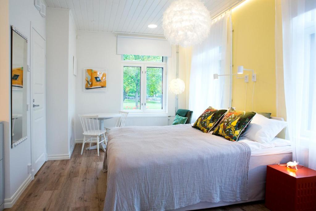 a bedroom with a bed and a dining room at Hotel Amandis in Naantali