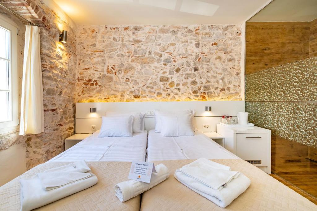a bedroom with a large bed with towels on it at Idassa Palace rooms in Zadar