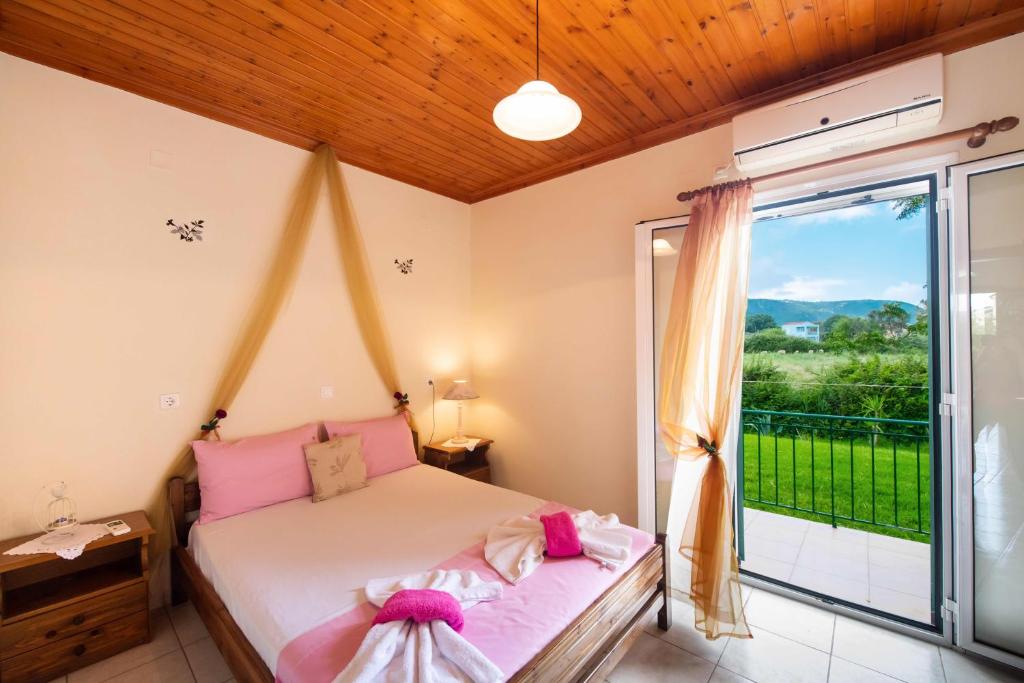 a bedroom with a bed and a large window at Studios Katopodi in Lefkada Town