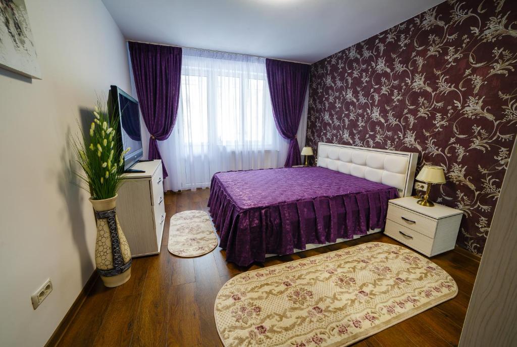 a bedroom with a purple bed and purple walls at ROMANTIK APARTMENTS in Câmpulung Moldovenesc