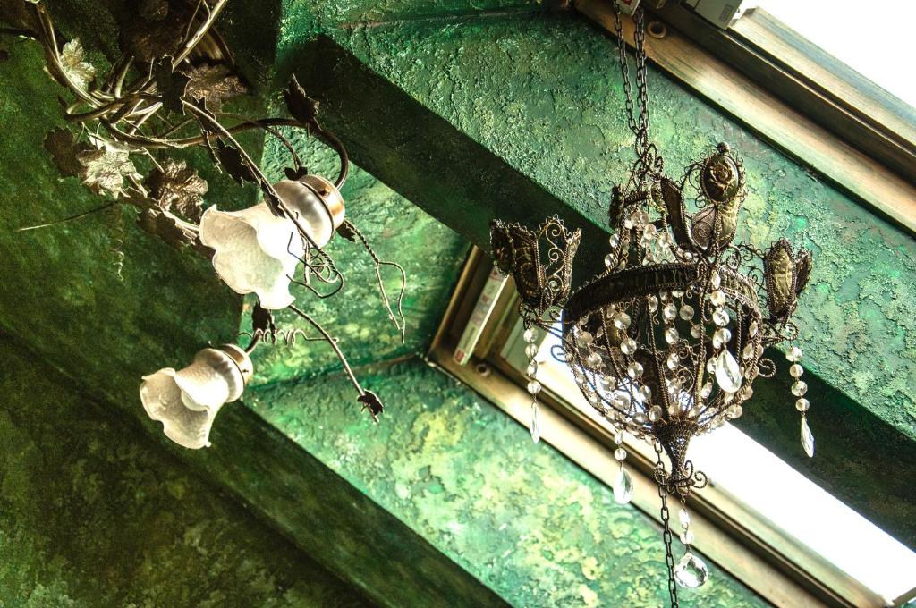 a chandelier hanging from a wall next to a mirror at Attic Apartment Warszawa in Warsaw