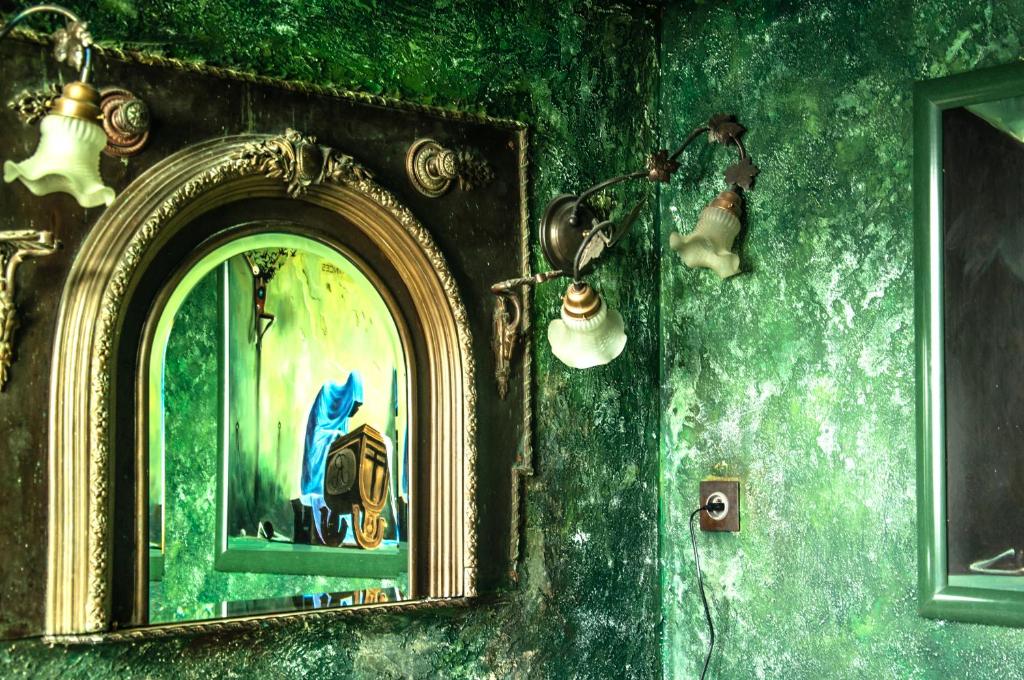 a mirror in a room with a green wall at Attic Apartment Warszawa in Warsaw
