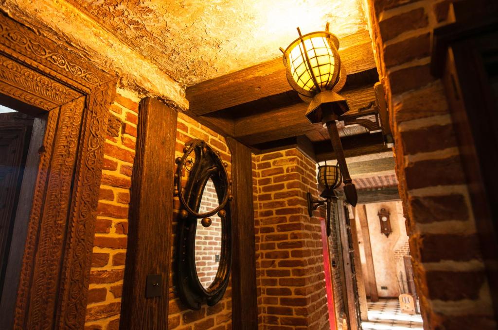 a room with a lamp and a brick wall at Attic Apartment Warszawa in Warsaw