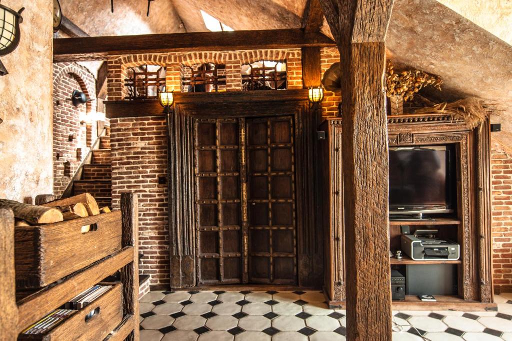 a room with a wooden door and a television at Attic Apartment Warszawa in Warsaw