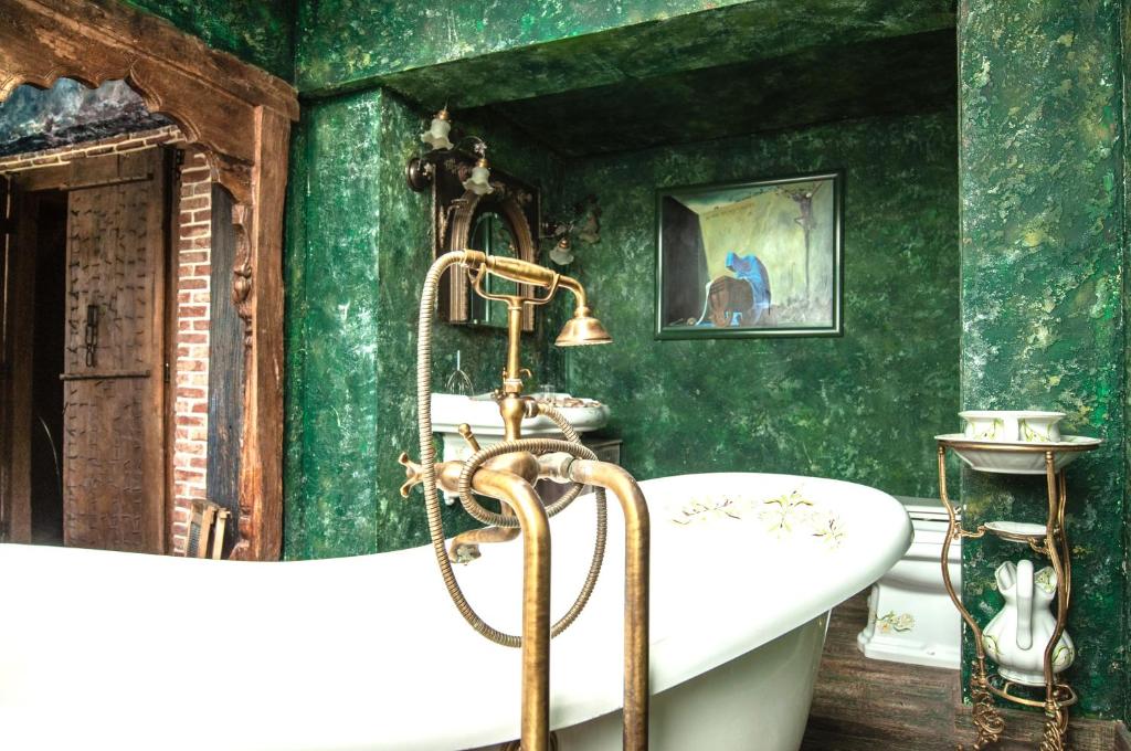 a bathroom with green walls and a bath tub at Attic Apartment Warszawa in Warsaw