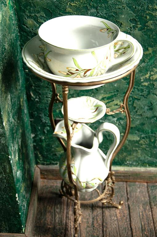 a white plate on a stand with a hat on it at Attic Apartment Warszawa in Warsaw