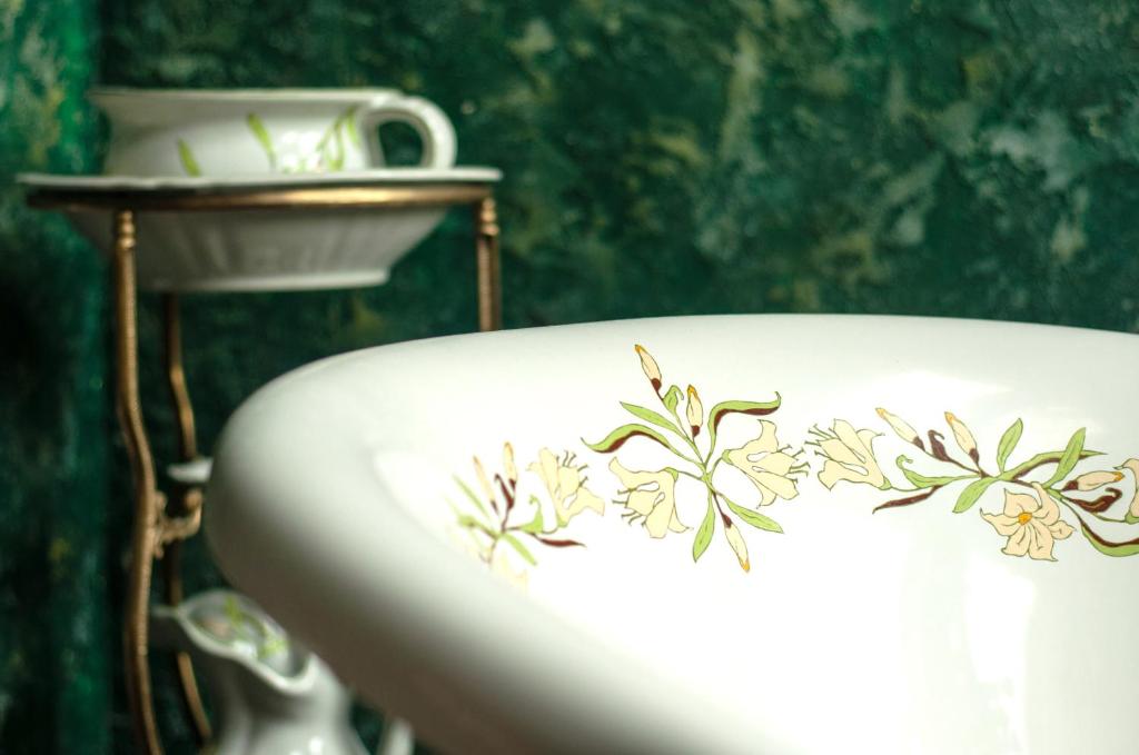 a white sink with flowers painted on it at Attic Apartment Warszawa in Warsaw