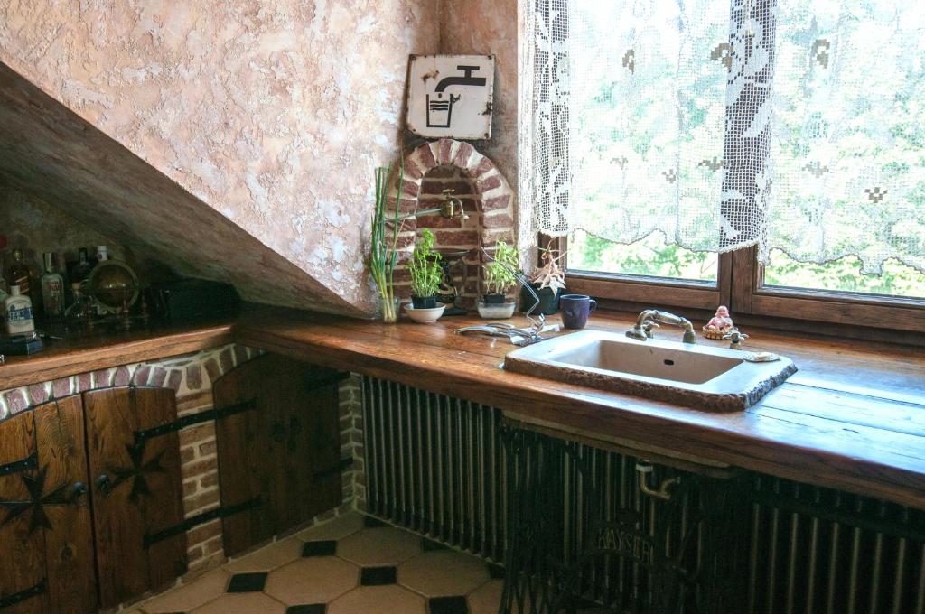 a kitchen with a sink and a window at Attic Apartment Warszawa in Warsaw