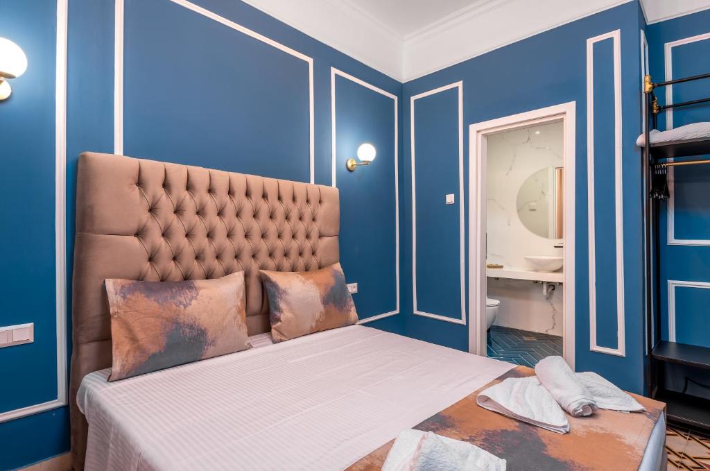 a bedroom with a bed with blue walls at Casa De La Sera in Rhodes Town