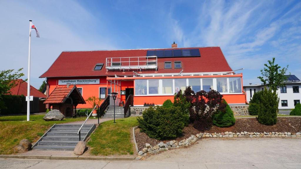 uma casa laranja com um telhado vermelho em Landhaus Mecklenburg em Waren