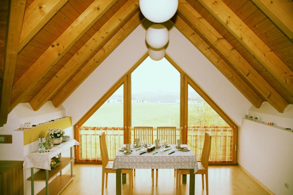 ein Esszimmer mit einem Tisch und Stühlen sowie einem großen Fenster in der Unterkunft Marga`s Ferienwohnung in Lembach im Mühlkreis