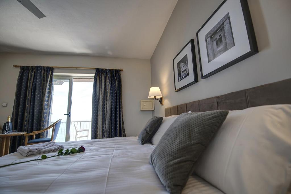 Postel nebo postele na pokoji v ubytování Sliema Chalet Hotel