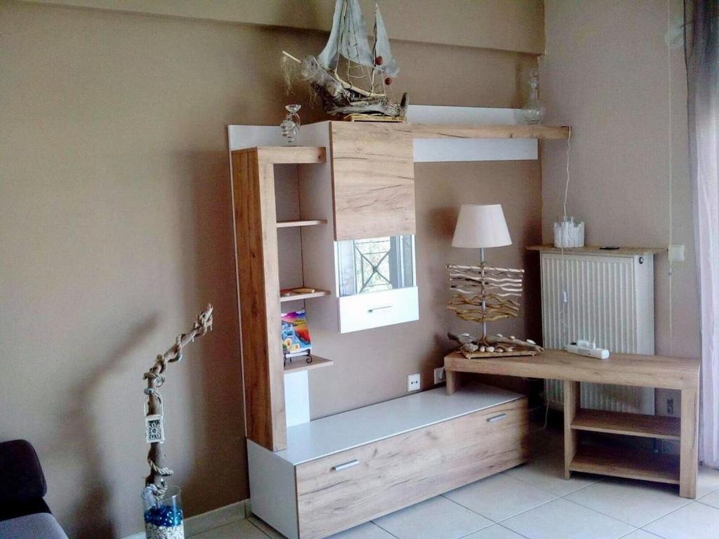a room with a desk and a table with a lamp at Ester's Sea Side apartment in Neoi Epivates