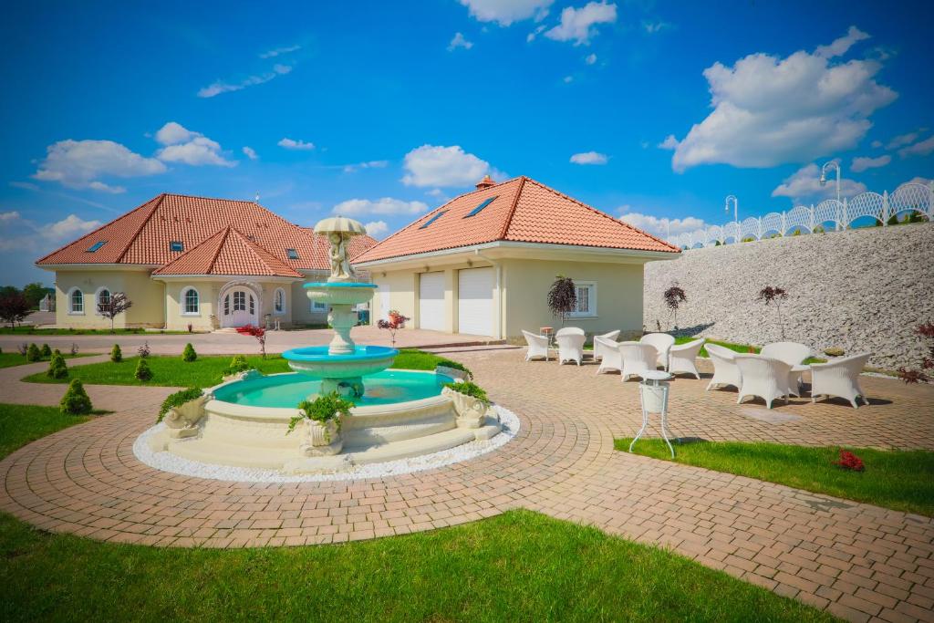 a house with a fountain in the middle of a patio at Sękowski Dwór in Sękowa