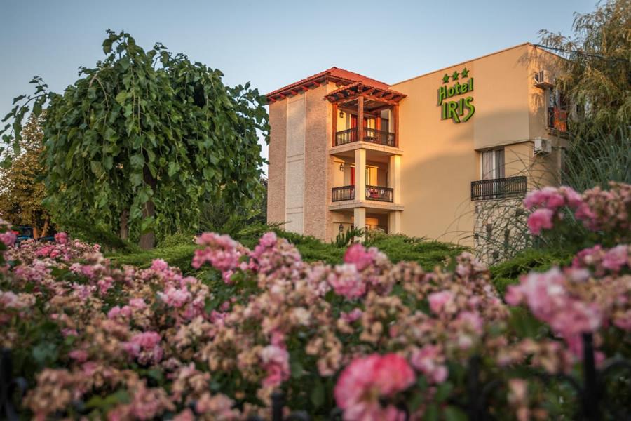 un edificio con fiori rosa di fronte di Complex Hotelier Iris-Mimoza a Jupiter