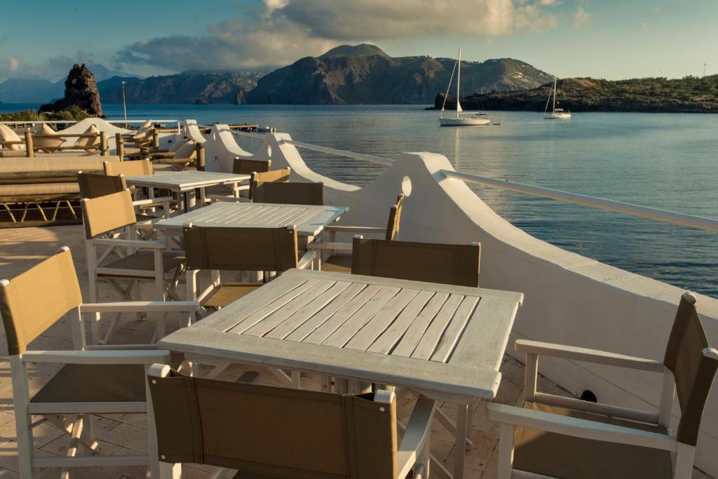 a group of tables and chairs on a boat in the water at Mari del Sud Resort in Vulcano