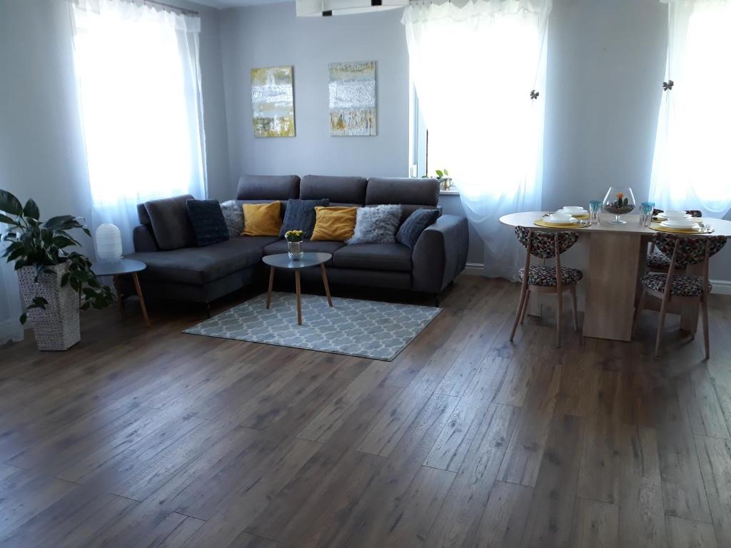 ein Wohnzimmer mit einem Sofa und einem Tisch in der Unterkunft Apartament WIKA in Wieliczka