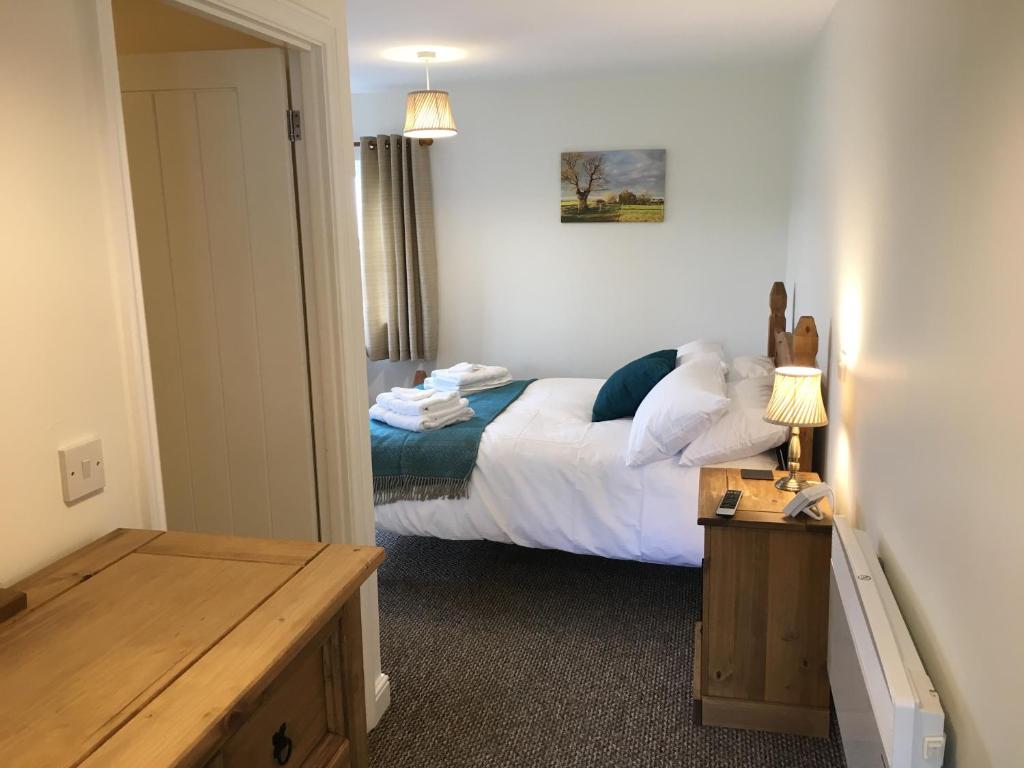 a bedroom with a bed and a table in it at The Stables Kings Ripton in Huntingdon