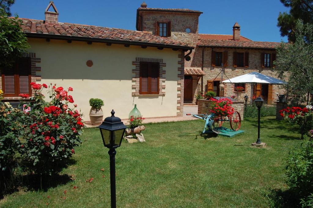 una casa con un cortile con un lampione di Agriturismo Podere Ranciano Alto a Castiglione del Lago