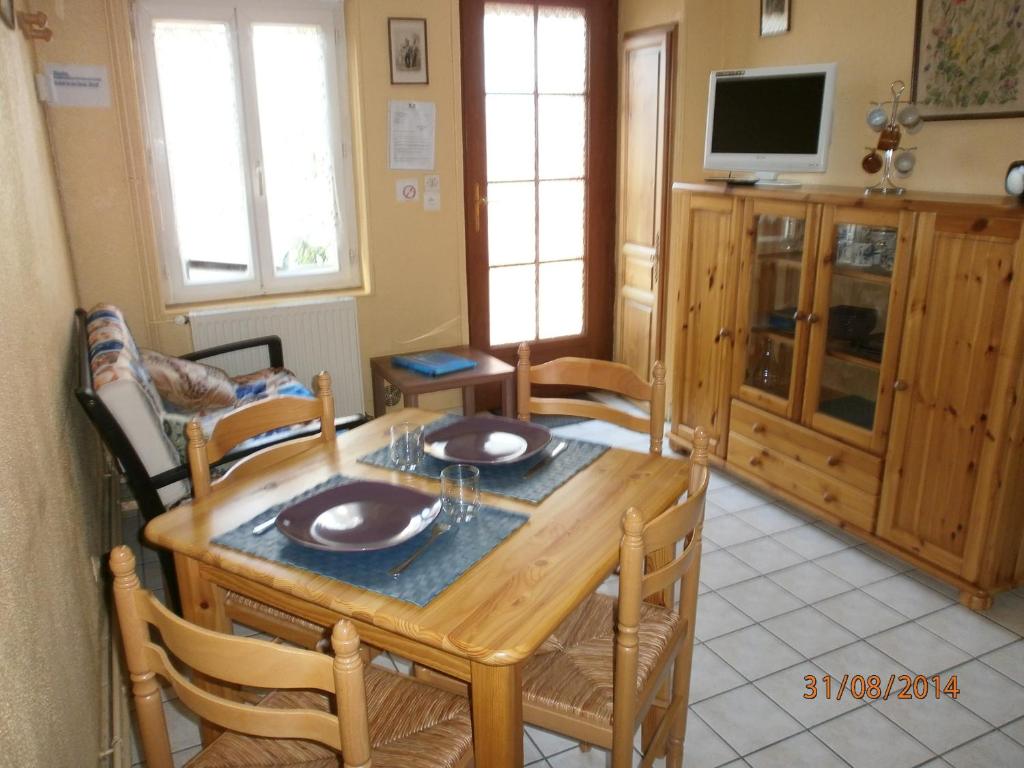 - une salle à manger avec une table et des chaises en bois dans l'établissement Gite Vallée de Seine, à Lillebonne