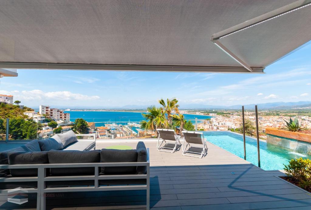 a living room with a couch and a swimming pool at Vista Roses Mar - Cap Ponent in Roses